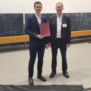 Prof. Dr. Renke Maas übergibt Michael Sponfeldner die Urkunde des Nachwuchspreises der DGPT